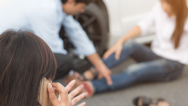 A woman injured in a Houston car accident being attended to by a bystander.
