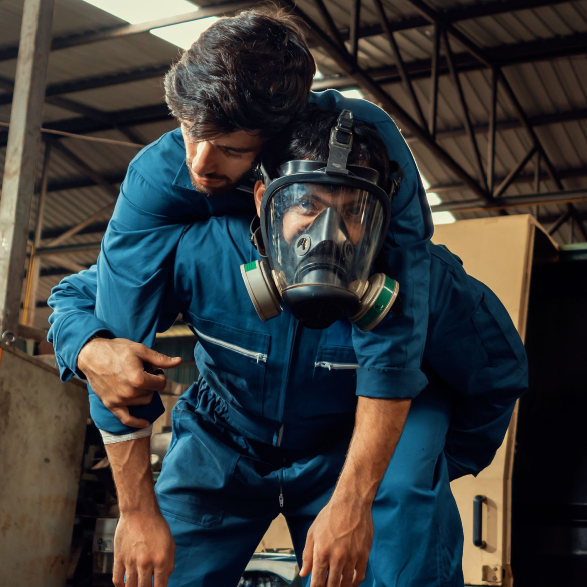 Worker in gas mask rescues a victim of a Houston chemical plant accident.